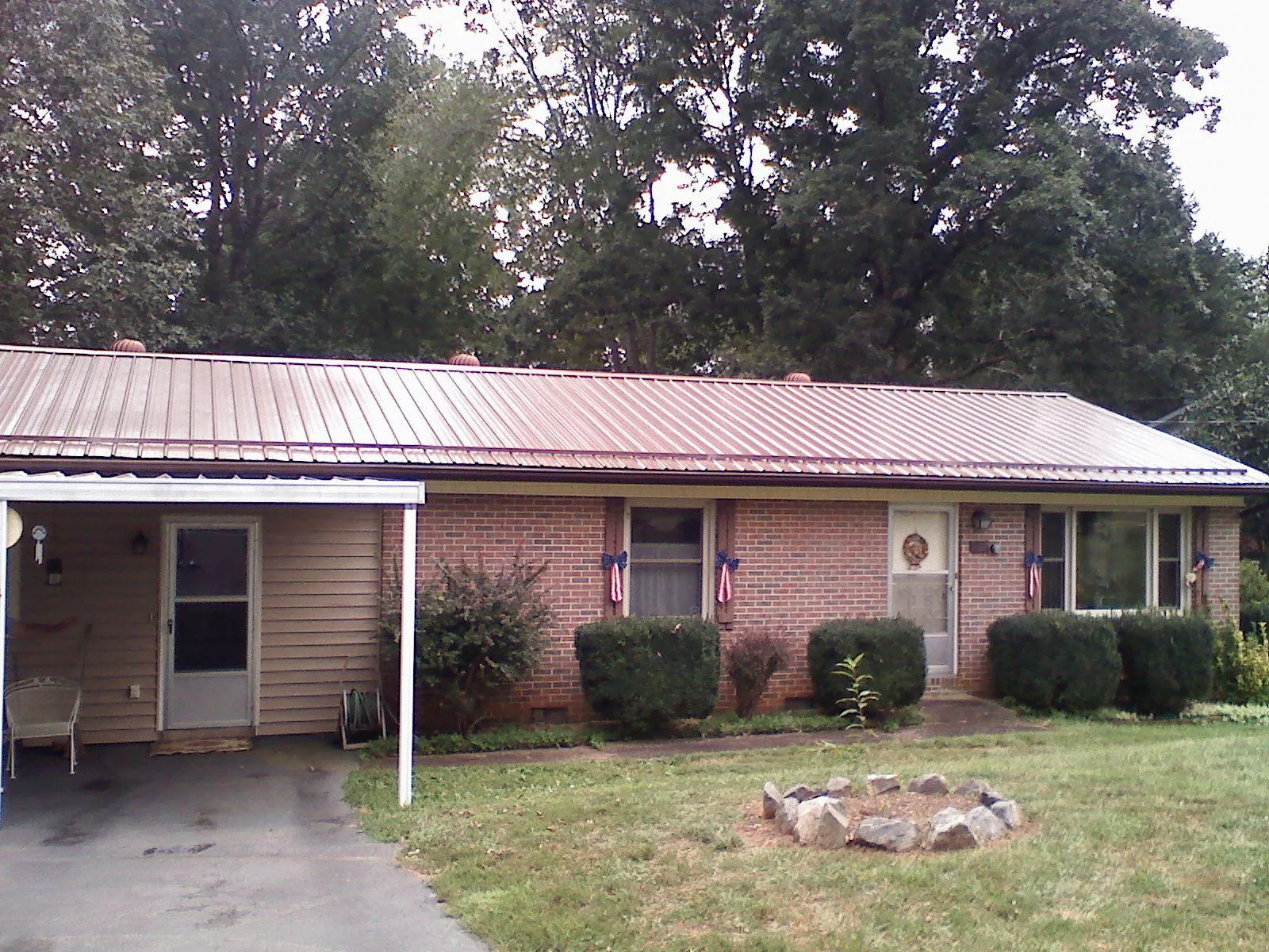 Bronze metal roof and carport on a brick ranch home — Roof Repair work by our crew in Due West